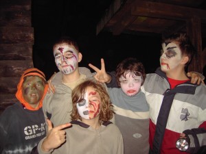 Fünf Jungs sind gruselig passend zu Halloween geschminkt. Es ist bereits dunkel und die Jungen posieren für die Kamera und machen ernste Gesichter.